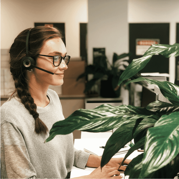 A support staff member wearing a call headset and smiling