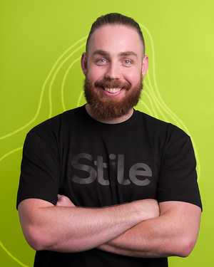 A black & white portrait of Stile team member Nick Spain smiling at the camera