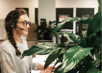 A support staff member wearing a call headset and smiling