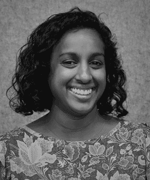 A black & white portrait of Stile team member Jayde Taylor smiling at the camera