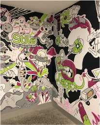 The mural in Stile HQ's foyer. It is full of cartoon-style artwork in black and white, with green and pink accents