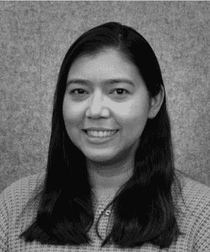 A black & white portrait of Stile team member Kelly Fernandez smiling at the camera