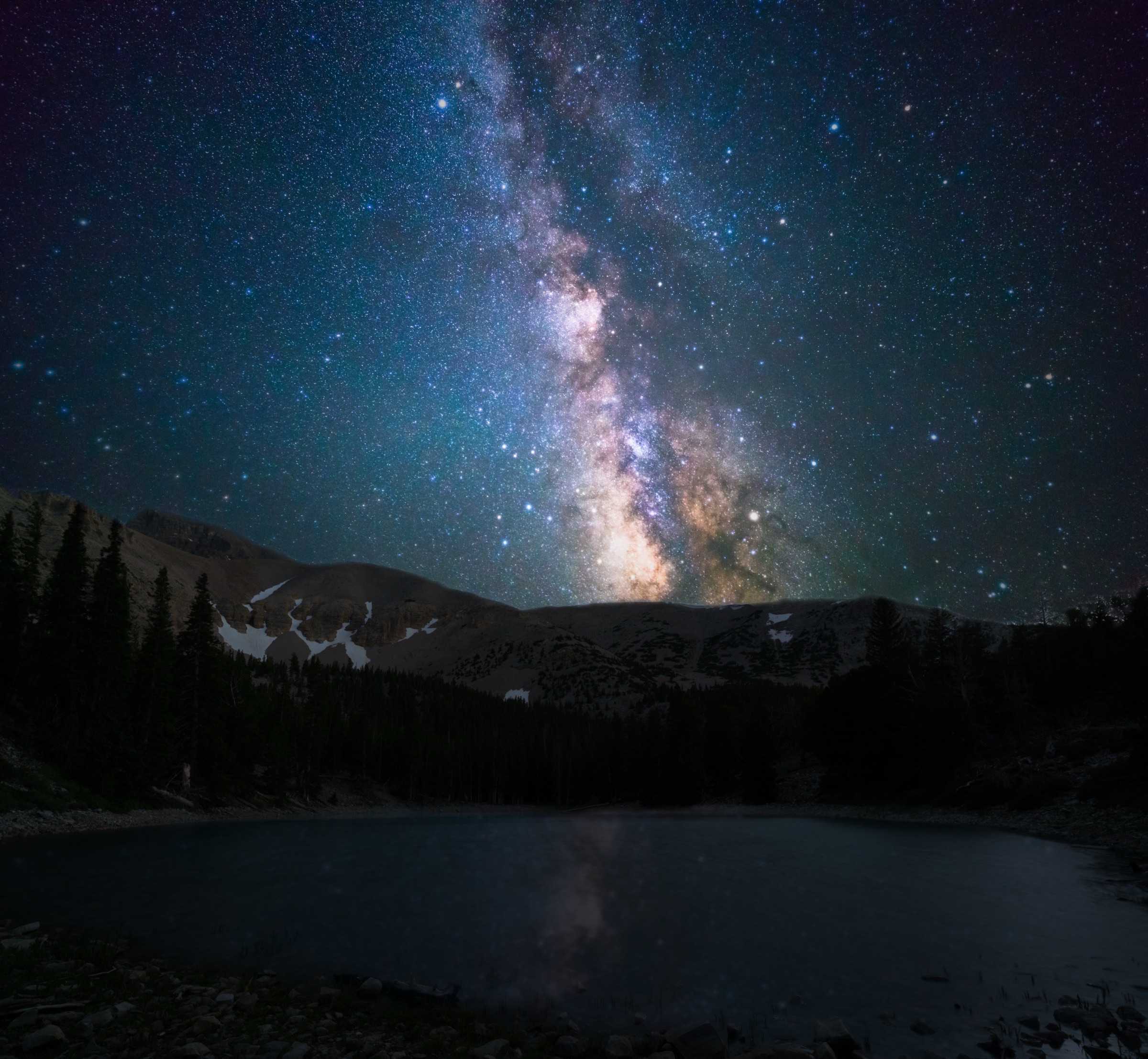 The Milky Way above dark mountains and a still lake in Great Basin National Park.