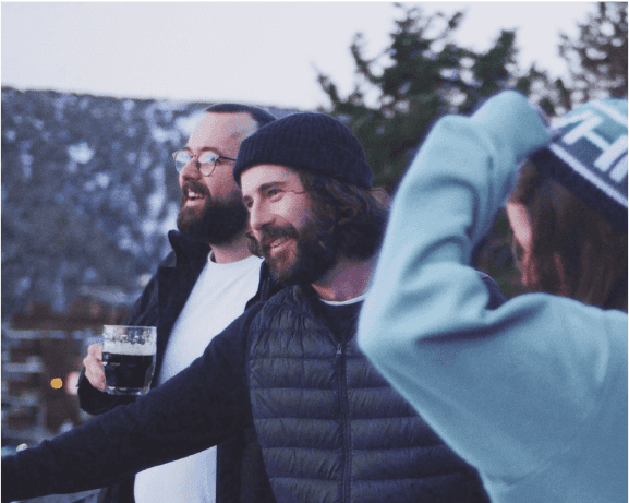 Three team members in warm clothes, with a snowy background