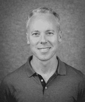 A black & white portrait of Stile team member Campbell Edgar smiling at the camera