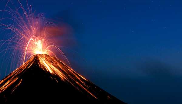 A volcano exploding at night