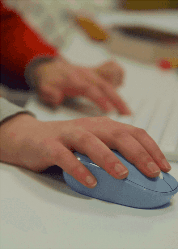 A closeup of someone's hand resting on a blue computer mouse