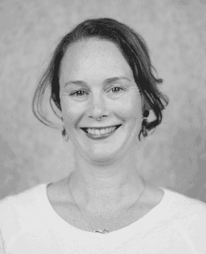 A black & white portrait of Stile team member Simone Gregurke smiling at the camera