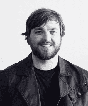 A black & white portrait of Stile team member Daniel Rodgers-Pryor smiling at the camera