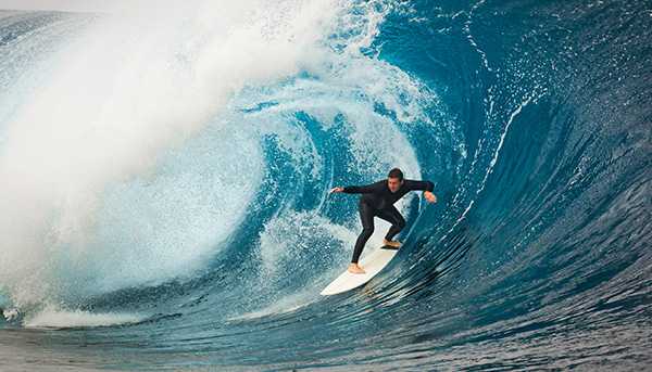 A surfer rides a very large wave